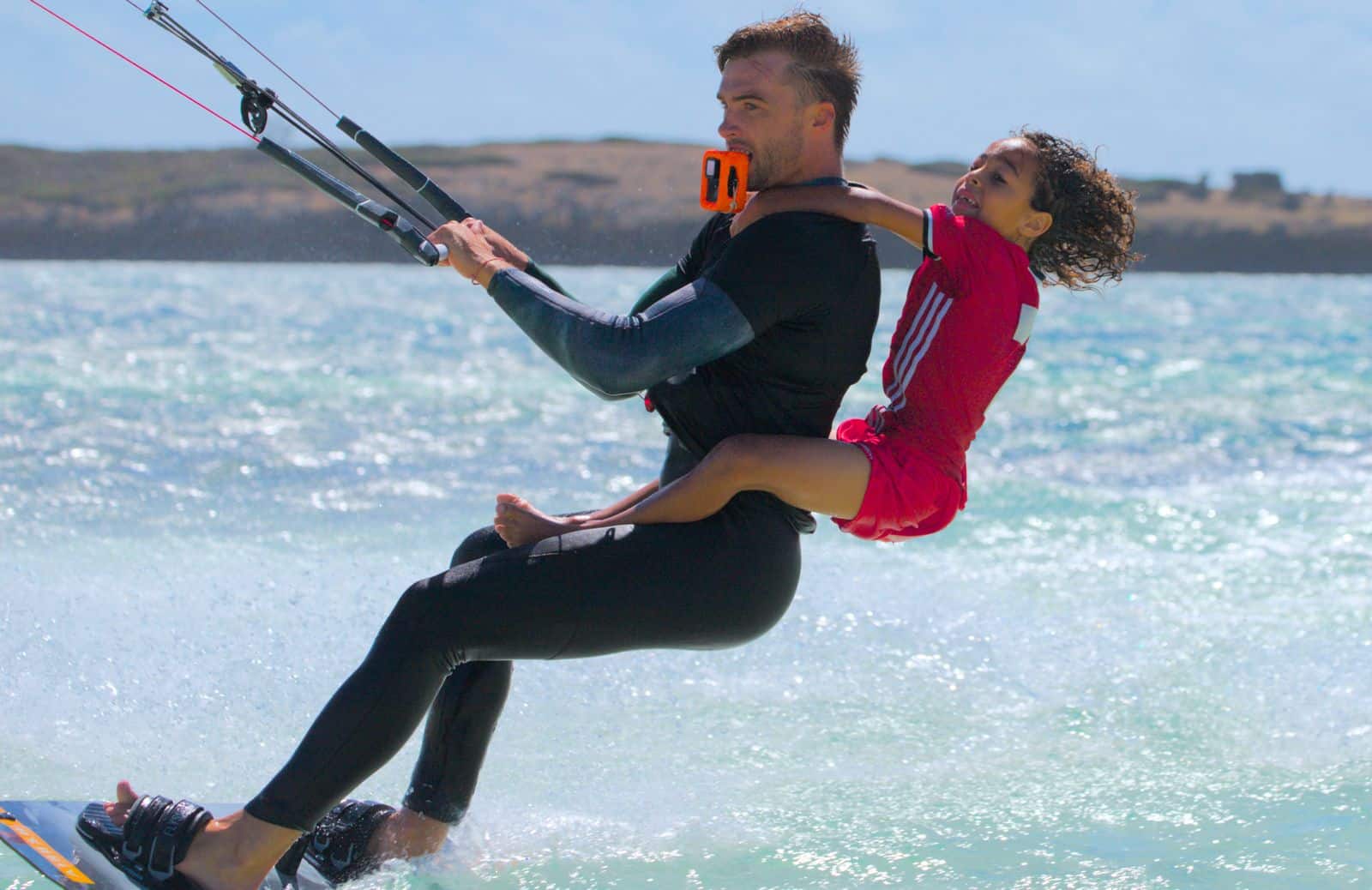 Enfant en tandem avec un moniteur pro sur un kite à Sakalava Bay, Madagascar