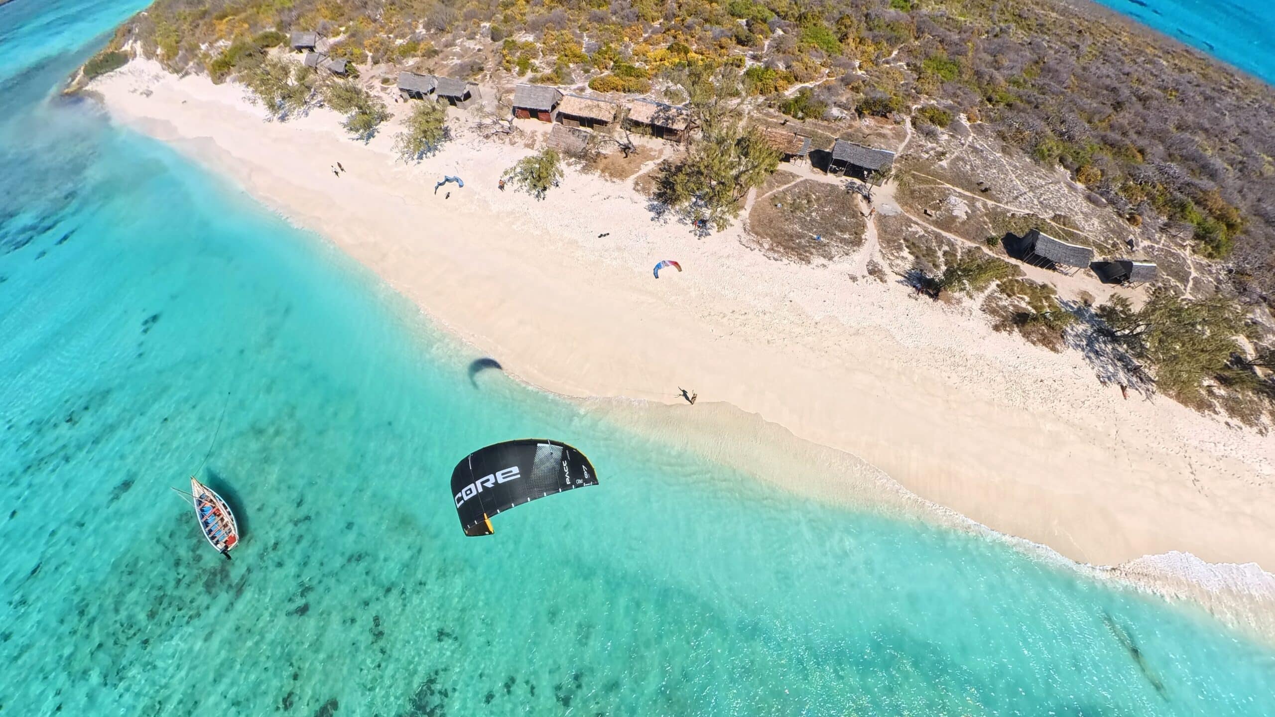 Vue aérienne de la plage et du lagon de la Mer d’Émeraude avec un kite et une pirogue, Madagascar